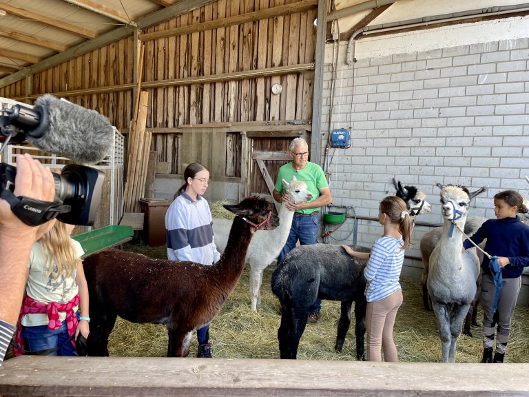 Peter Egli, Leiter der CurlyRanch, instruiert die Kinder im Umgang mit den Alpakas | © 2023 ALPHAVISION