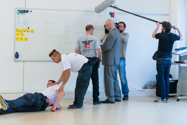 Kosmas Mutter bespricht mit einem der Lehrer den Ausbildungsstand.