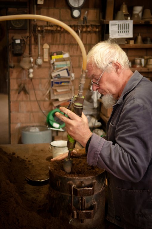 Mitarbeiter Peter Bilang verfestigt den Sand, den er für die Bildung eines 